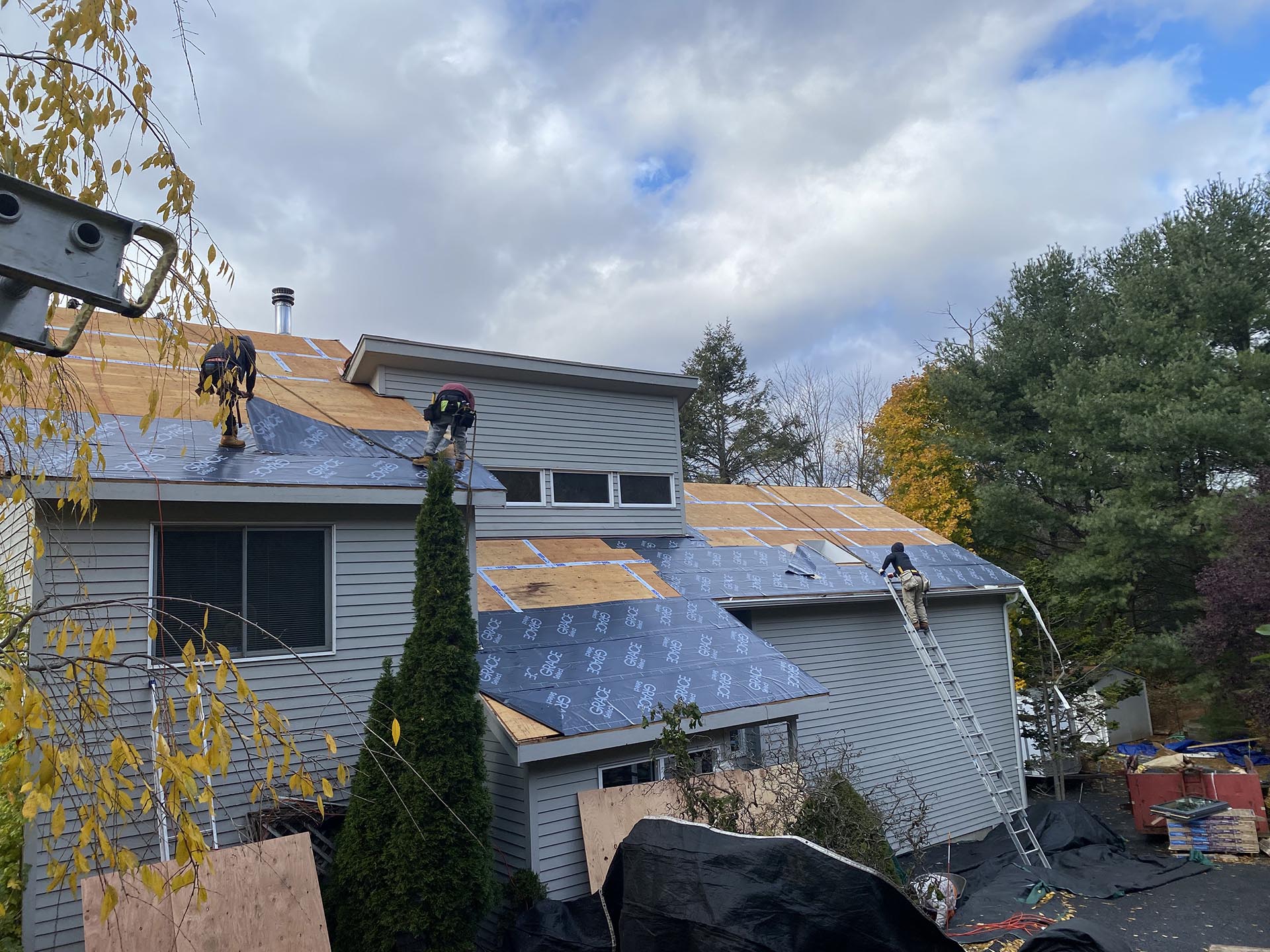Able Roofing crew installing underlayment across a multi-level home